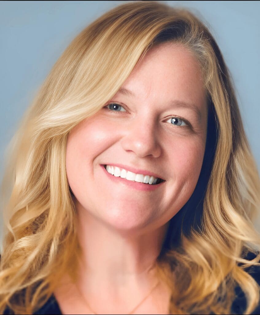 A smiling woman with blonde hair against a light blue background.